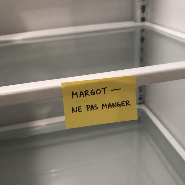 Charming ink and watercolor painting, clean lines, vibrant but soft color palette, storybook style. A close-up photo of the inside of an office refrigerator shelf, slightly blurry as if taken quickly on a phone. A small yellow sticky note is stuck to an otherwise empty section of the shelf. Visible text: "MARGOT — NE PAS MANGER". No other readable text. The shelf is bare around the note, no food visible nearby
Chat attachment instruction: Generate exactly one in-world chat attachment, not a collage, split-screen, comic panel, flashback, or explanatory scene. If the prompt is a screenshot, phone screen, document, note, card, map, receipt, label, object photo, or photo someone took, frame that artifact directly. A name appearing in visible text or in 'photo taken by X' is not an instruction to draw that person. Do not show recurring story participants as visible people unless the prompt itself explicitly says they are visible. Keep unrequested people, faces, and bodies out of the image.