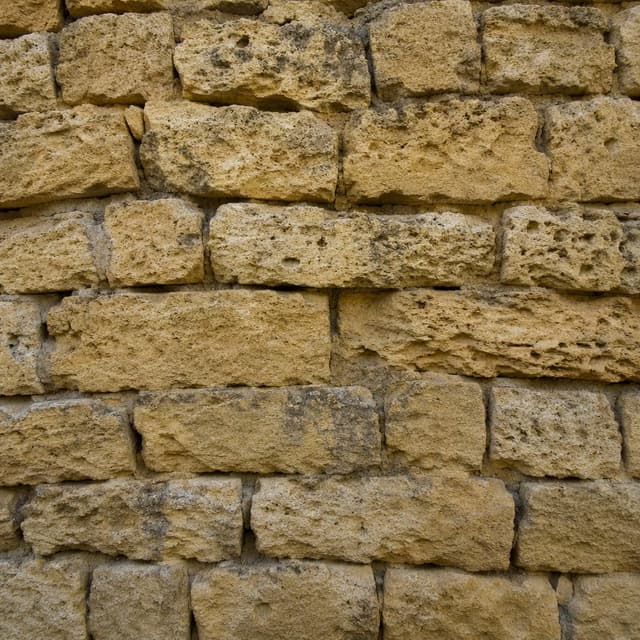 A rough, weathered stone wall with irregular horizontal layers of yellow tuff blocks
Chat attachment instruction: Generate exactly one in-world chat attachment, not a collage, split-screen, comic panel, flashback, or explanatory scene. If the prompt is a screenshot, phone screen, document, note, card, map, receipt, label, object photo, or photo someone took, frame that artifact directly. A name appearing in visible text or in 'photo taken by X' is not an instruction to draw that person. Do not show recurring story participants as visible people unless the prompt itself explicitly says they are visible. Keep unrequested people, faces, and bodies out of the image.