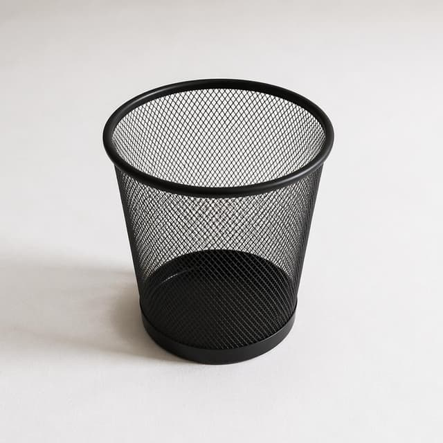 a small empty wastepaper basket on a plain white floor
Chat attachment instruction: Generate exactly one in-world chat attachment, not a collage, split-screen, comic panel, flashback, or explanatory scene. If the prompt is a screenshot, phone screen, document, note, card, map, receipt, label, object photo, or photo someone took, frame that artifact directly. A name appearing in visible text or in 'photo taken by X' is not an instruction to draw that person. Do not show recurring story participants as visible people unless the prompt itself explicitly says they are visible. Keep unrequested people, faces, and bodies out of the image.