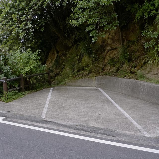 a single empty concrete parking space on a quiet hillside road
Chat attachment instruction: Generate exactly one in-world chat attachment, not a collage, split-screen, comic panel, flashback, or explanatory scene. If the prompt is a screenshot, phone screen, document, note, card, map, receipt, label, object photo, or photo someone took, frame that artifact directly. A name appearing in visible text or in 'photo taken by X' is not an instruction to draw that person. Do not show recurring story participants as visible people unless the prompt itself explicitly says they are visible. Keep unrequested people, faces, and bodies out of the image.