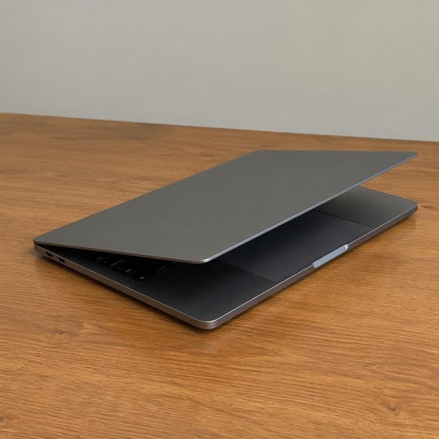 A laptop with the lid half-closed, resting on a plain wooden desk
Chat attachment instruction: Generate exactly one in-world chat attachment, not a collage, split-screen, comic panel, flashback, or explanatory scene. If the prompt is a screenshot, phone screen, document, note, card, map, receipt, label, object photo, or photo someone took, frame that artifact directly. A name appearing in visible text or in 'photo taken by X' is not an instruction to draw that person. Do not show recurring story participants as visible people unless the prompt itself explicitly says they are visible. Keep unrequested people, faces, and bodies out of the image.