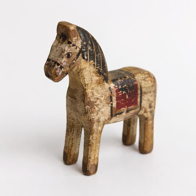 a small worn wooden toy horse on a plain white surface
Chat attachment instruction: Generate exactly one in-world chat attachment, not a collage, split-screen, comic panel, flashback, or explanatory scene. If the prompt is a screenshot, phone screen, document, note, card, map, receipt, label, object photo, or photo someone took, frame that artifact directly. A name appearing in visible text or in 'photo taken by X' is not an instruction to draw that person. Do not show recurring story participants as visible people unless the prompt itself explicitly says they are visible. Keep unrequested people, faces, and bodies out of the image.