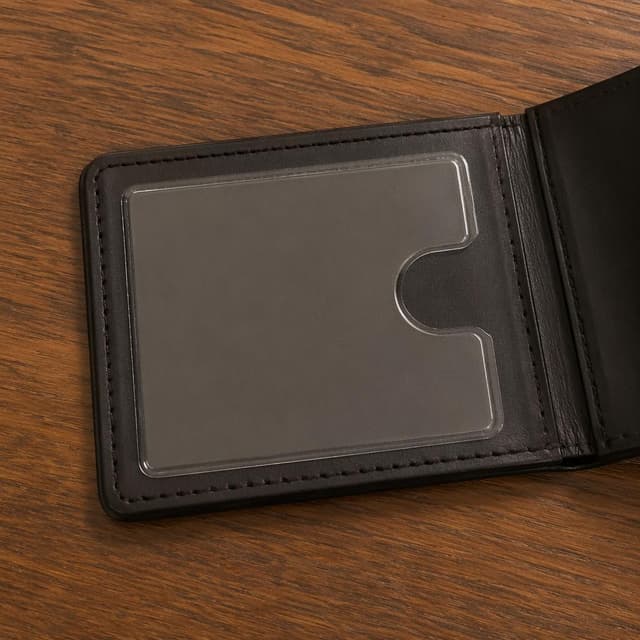 A first-person view looking down at a wooden desk, showing an empty plastic card slot in a wallet or holder
Chat attachment instruction: Generate exactly one in-world chat attachment, not a collage, split-screen, comic panel, flashback, or explanatory scene. If the prompt is a screenshot, phone screen, document, note, card, map, receipt, label, object photo, or photo someone took, frame that artifact directly. A name appearing in visible text or in 'photo taken by X' is not an instruction to draw that person. Do not show recurring story participants as visible people unless the prompt itself explicitly says they are visible. Keep unrequested people, faces, and bodies out of the image.