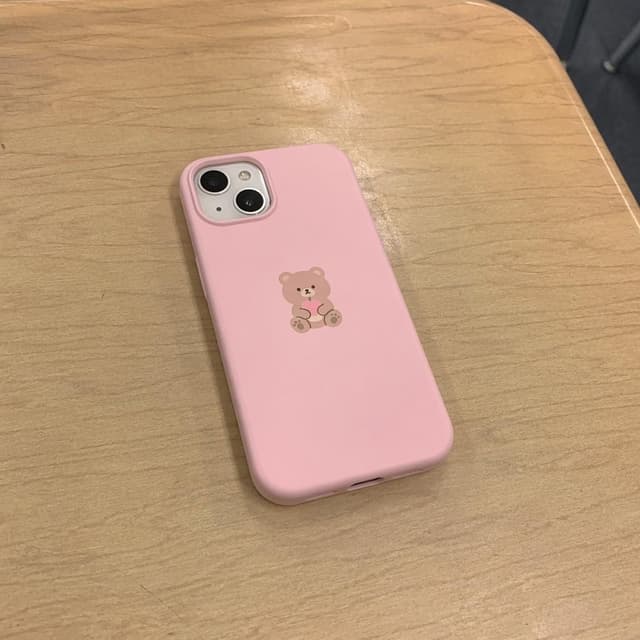 A pink phone case with a small cartoon bear design, lying on a plain wooden school desk
Chat attachment instruction: Generate exactly one in-world chat attachment, not a collage, split-screen, comic panel, flashback, or explanatory scene. If the prompt is a screenshot, phone screen, document, note, card, map, receipt, label, object photo, or photo someone took, frame that artifact directly. A name appearing in visible text or in 'photo taken by X' is not an instruction to draw that person. Do not show recurring story participants as visible people unless the prompt itself explicitly says they are visible. Keep unrequested people, faces, and bodies out of the image.