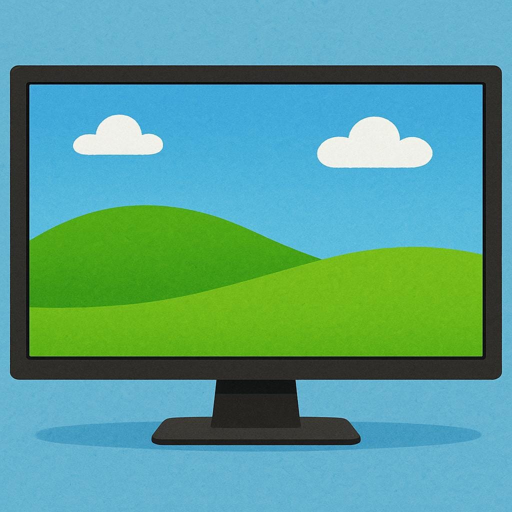 A brightly lit, rectangular computer monitor displaying a simple, colorful landscape with a blue sky and green hills.