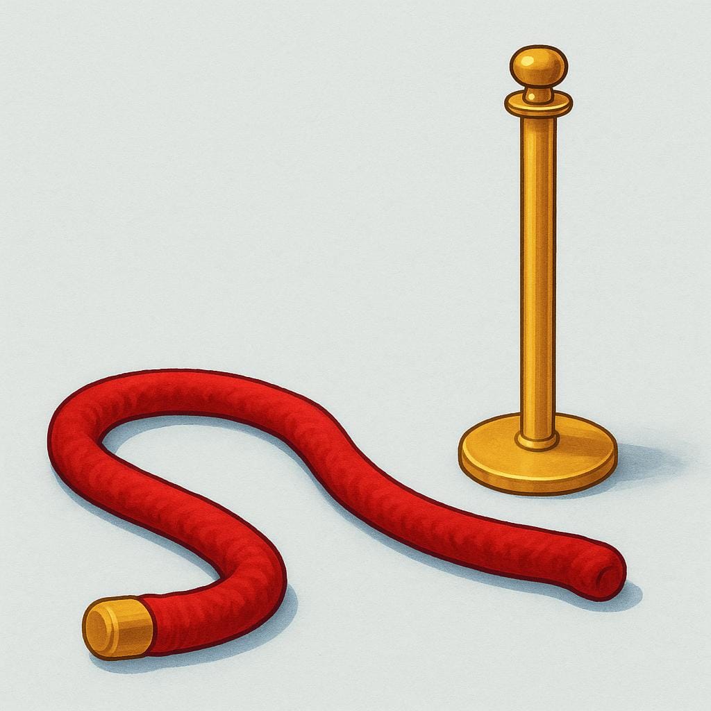 金色の支柱からフックが外され、地面に平らに置かれた厚い赤いベルベットロープのバリア。これはアクセスが許可されたことを示している。