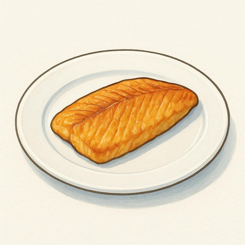A golden-brown, cooked fish fillet resting on a plain white plate, ready to be eaten.
