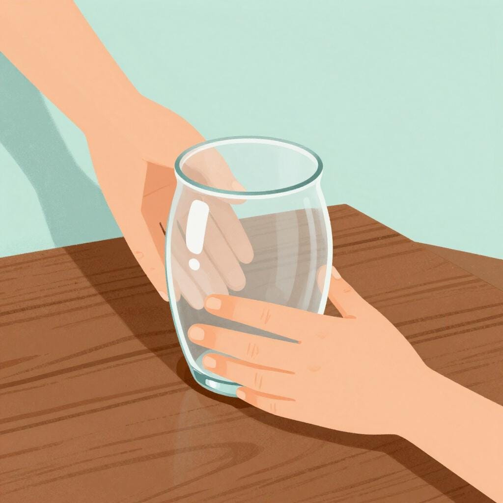 A person carefully placing a fragile glass vase onto a wooden table.