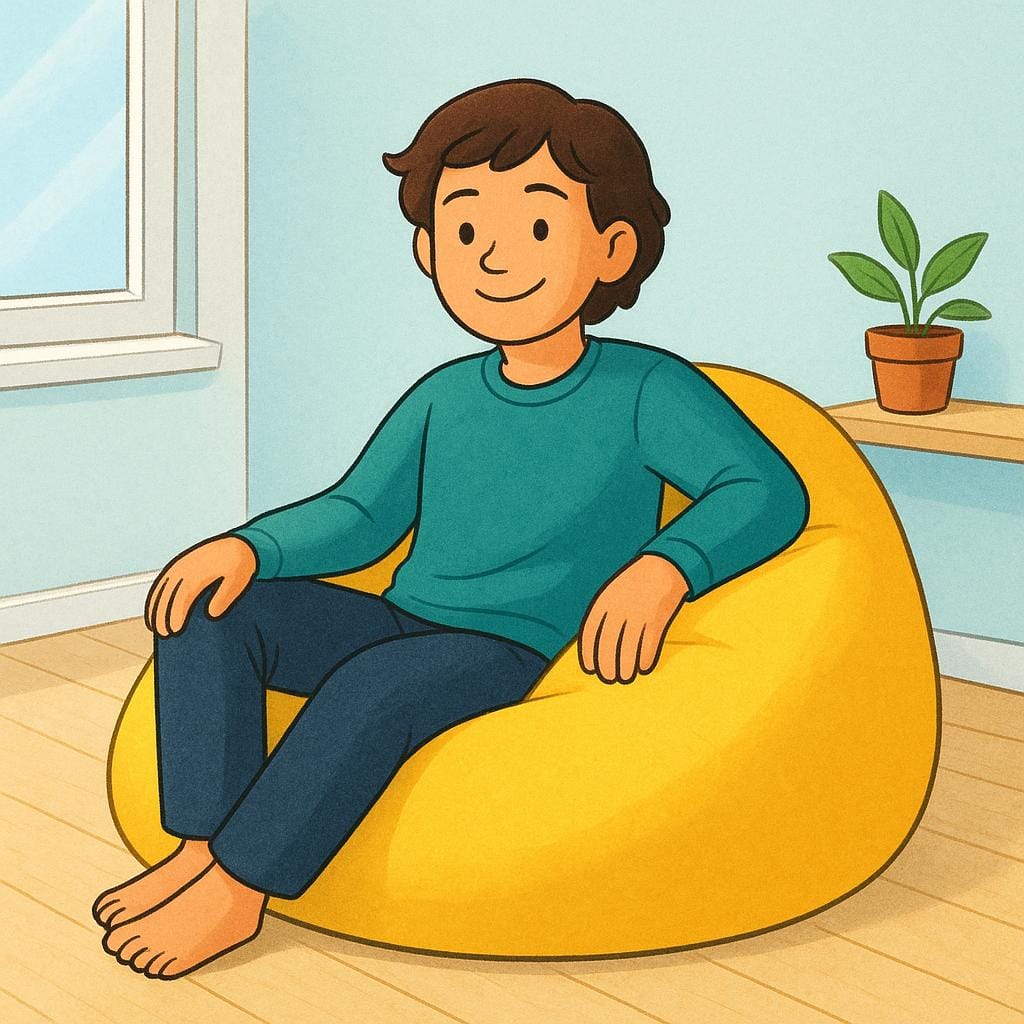 A friendly-looking young person is sitting comfortably and relaxed on a giant, bright yellow beanbag chair in a simple, sunny room.