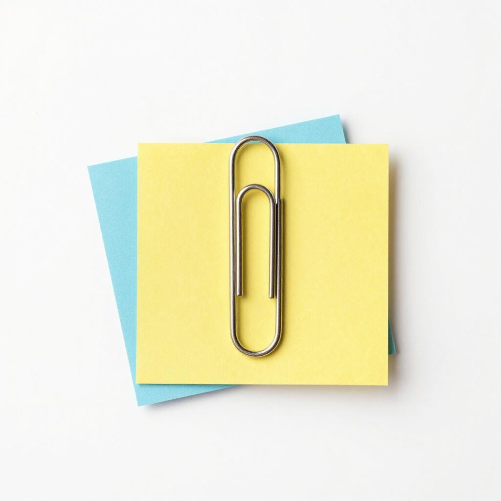 A paperclip holding several colorful sheets of paper together.