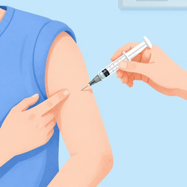 La main d'un médecin administrant soigneusement un vaccin avec une petite seringue dans le bras d'un patient.