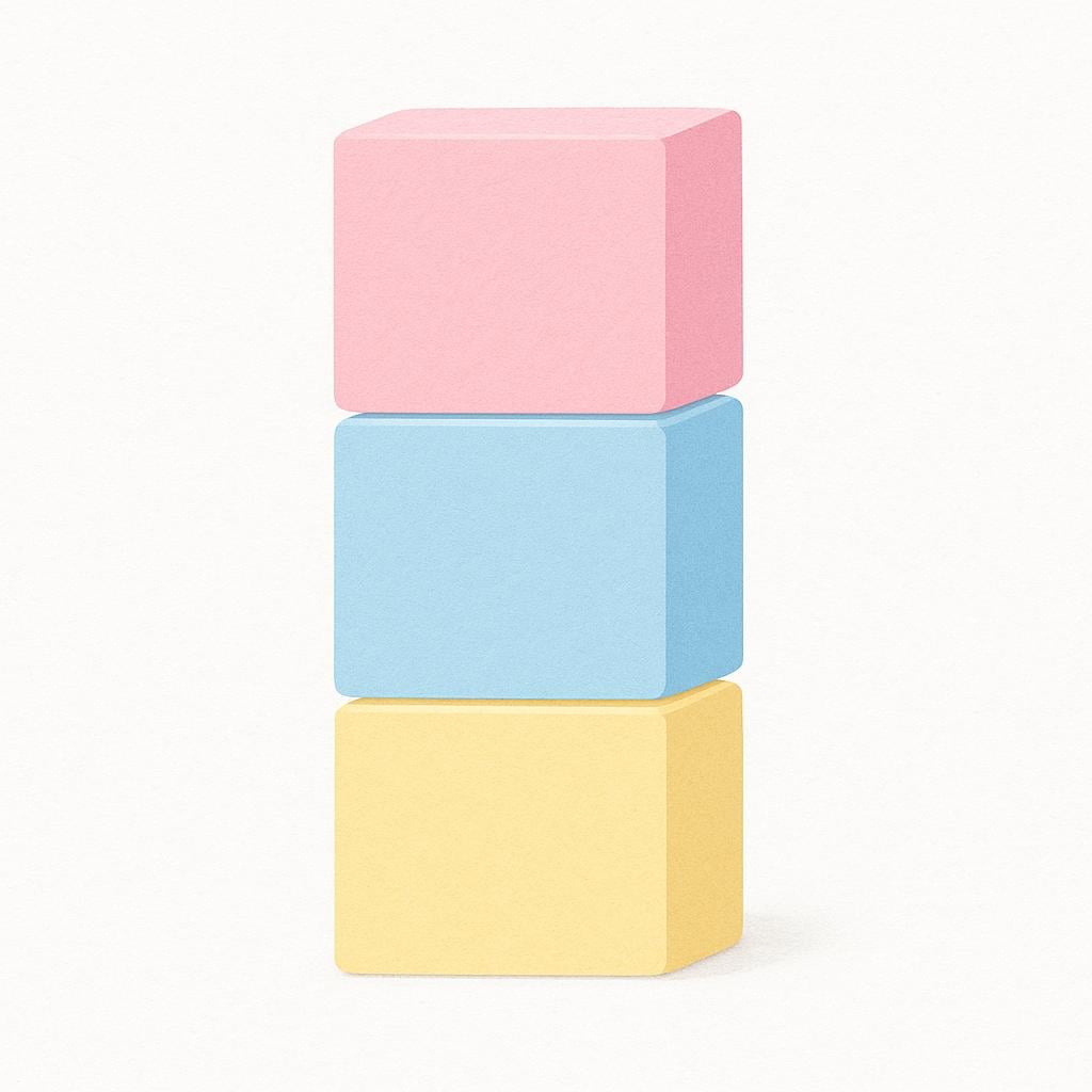 A collection of three simple, square blocks colored in very pale, soft pink, light blue, and pale yellow.