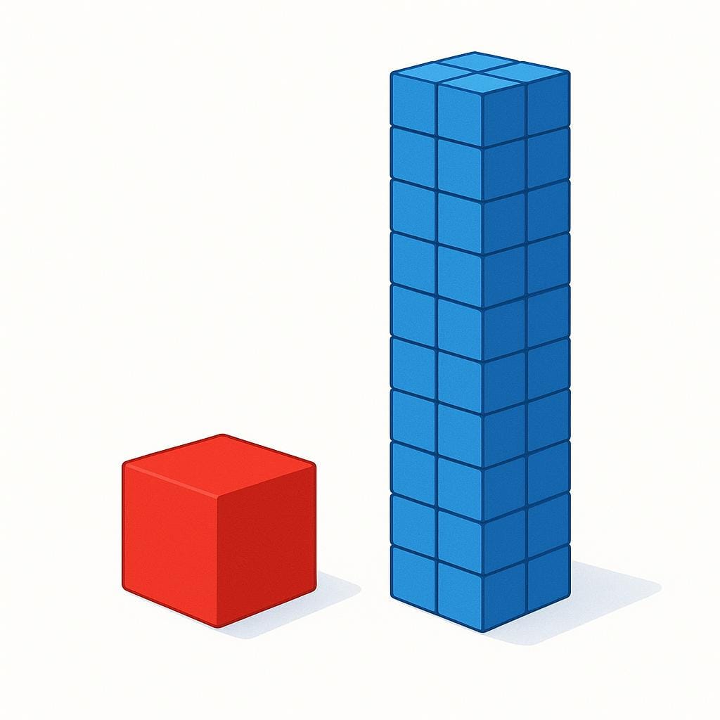 A single, perfectly smooth, solid red block standing alone next to a tall structure built entirely out of many small, identical blue blocks, illustrating the concept of a fundamental, indivisible unit.
