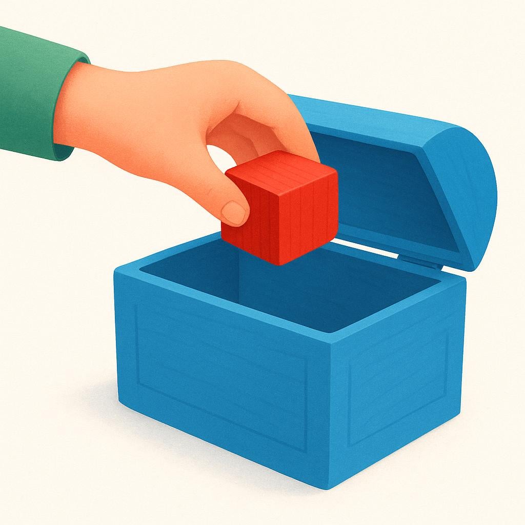 A child's hand putting a bright red wooden block into a simple open blue toy chest, illustrating the act of putting something inside.
