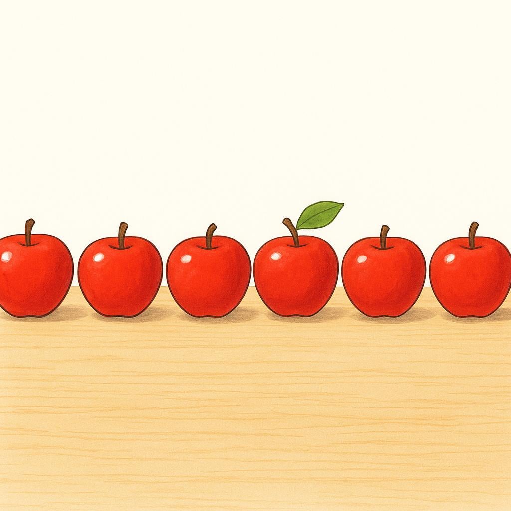 Seven bright red apples neatly arranged in a single line on a simple wooden surface.