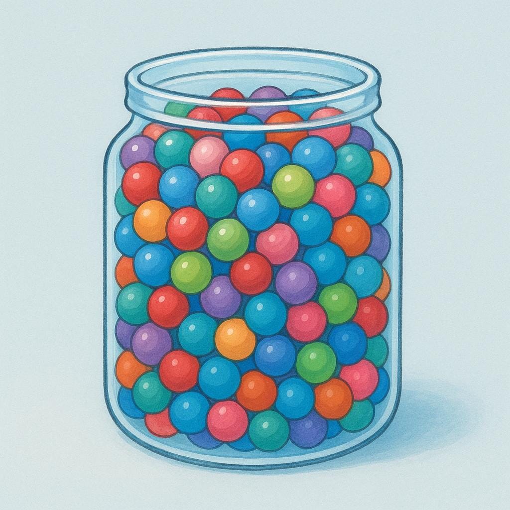 A transparent glass jar completely filled to the very top with small, colorful marbles, illustrating the maximum volume it can hold.