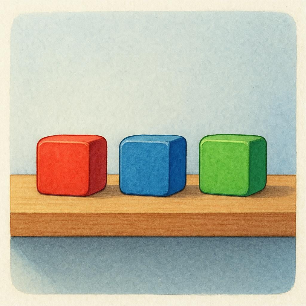 Three small, brightly colored toy blocks are sitting stationary on a wooden shelf in a quiet room, suggesting they have been left there.