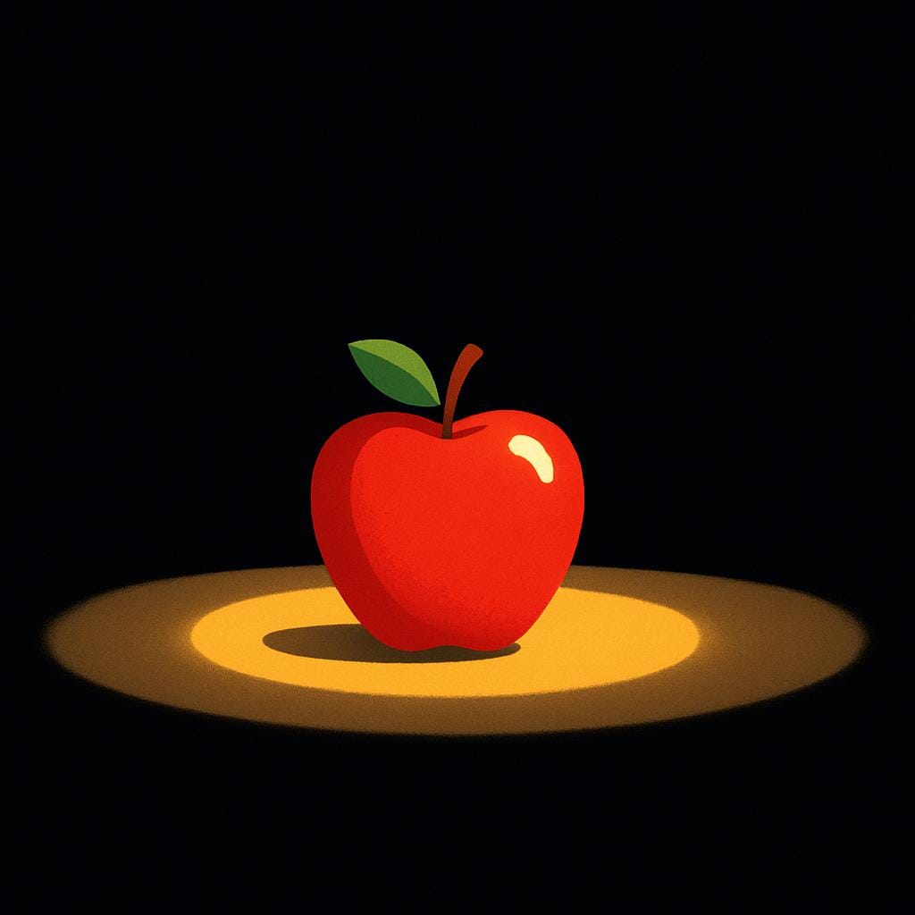 A red apple is partially lit by a small flashlight beam against a completely dark background.