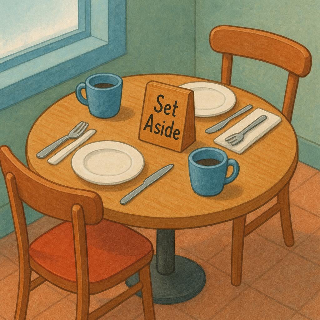 A small, empty restaurant table set for two, featuring a prominent 'Reserved' sign placed on the tabletop.