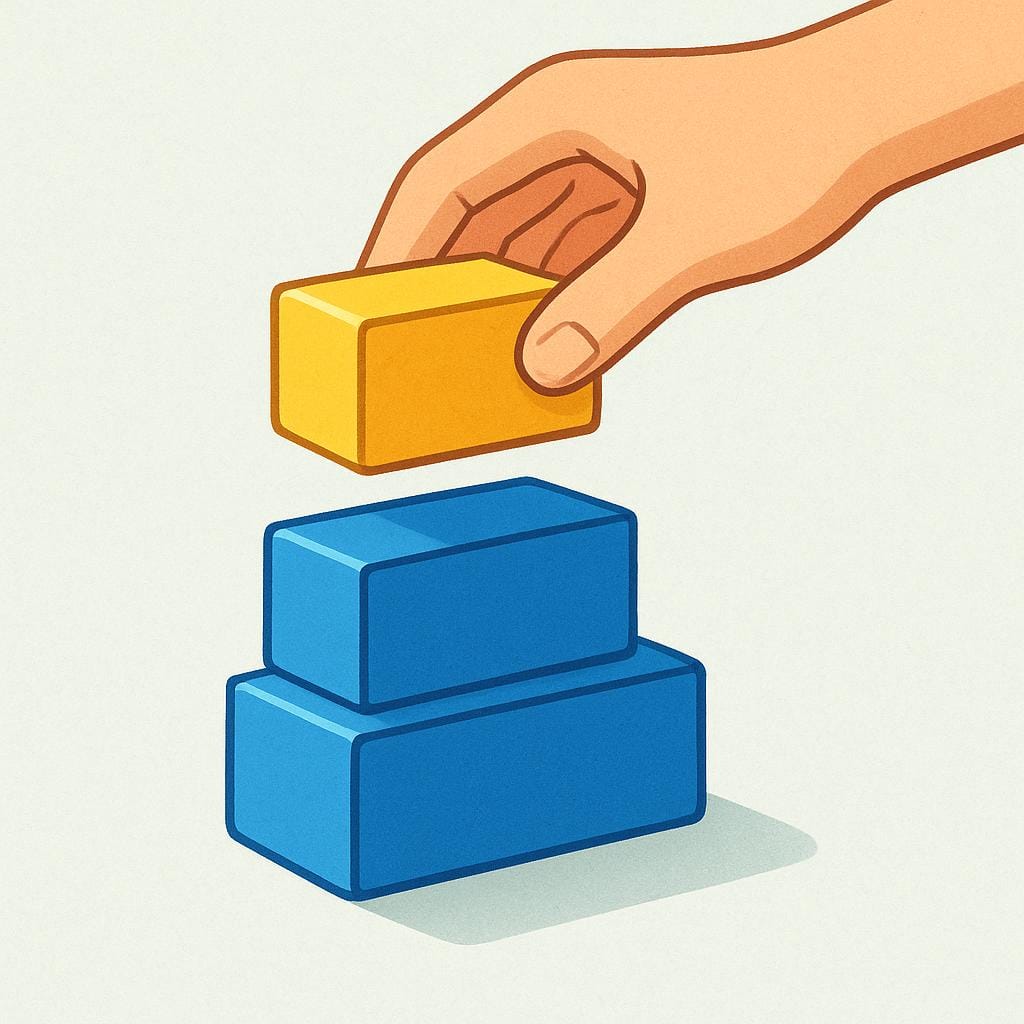 A simple yellow rectangular block being placed directly onto the top of a stack of blue rectangular blocks by a hand, symbolizing the action of joining.