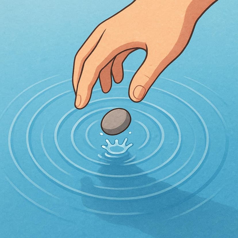 Una singola mano che lascia cadere una piccola pietra sulla superficie perfettamente immobile dell'acqua blu, creando increspature circolari espanse.