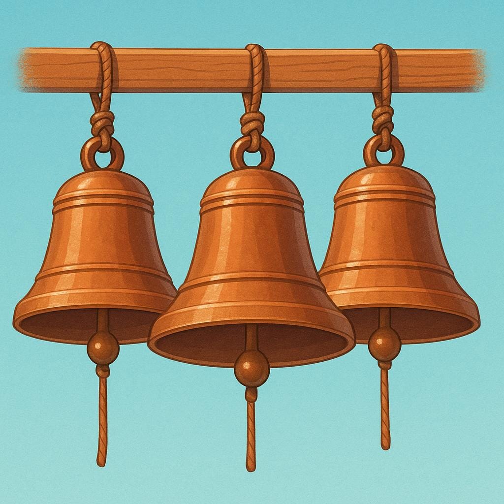 Three ornate bronze bells of varying sizes hanging side-by-side from wooden beams in a bell tower.