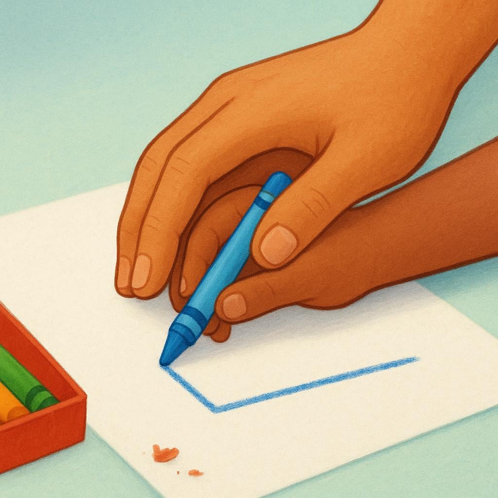An adult's hand is gently guiding a child's hand holding a crayon to draw a line on paper.