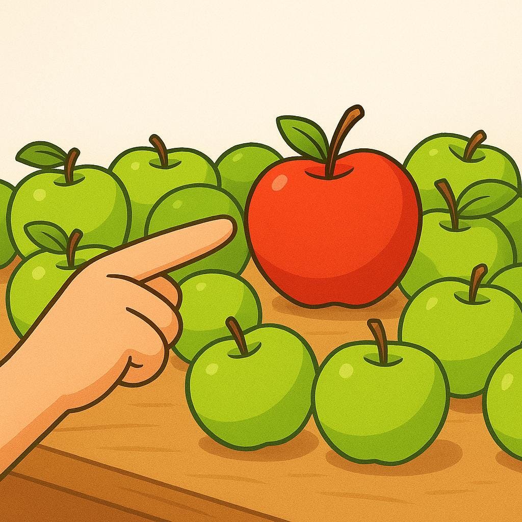 A stylized hand with a pointing finger clearly directs attention towards a single, brightly colored red apple on a table filled with green apples.