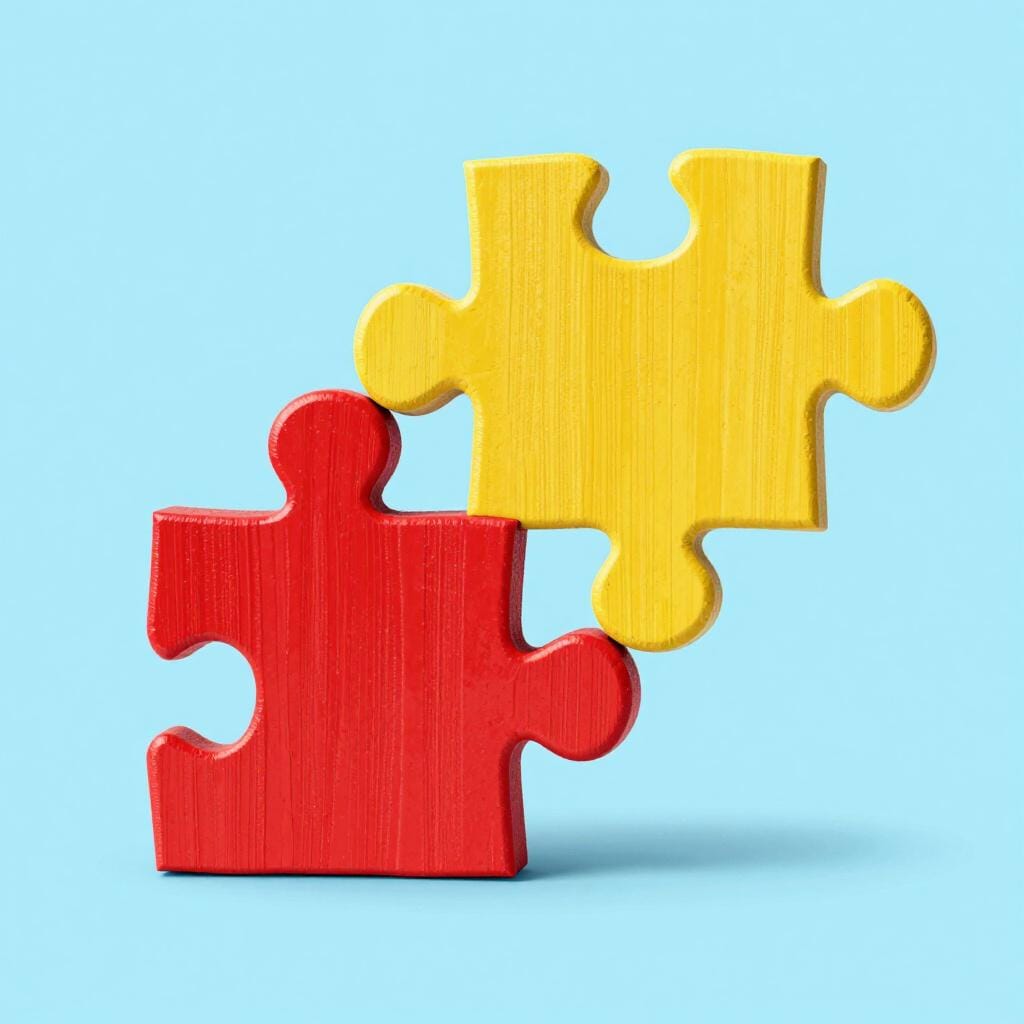 Twee houten puzzelstukjes die perfect in elkaar worden geduwd.