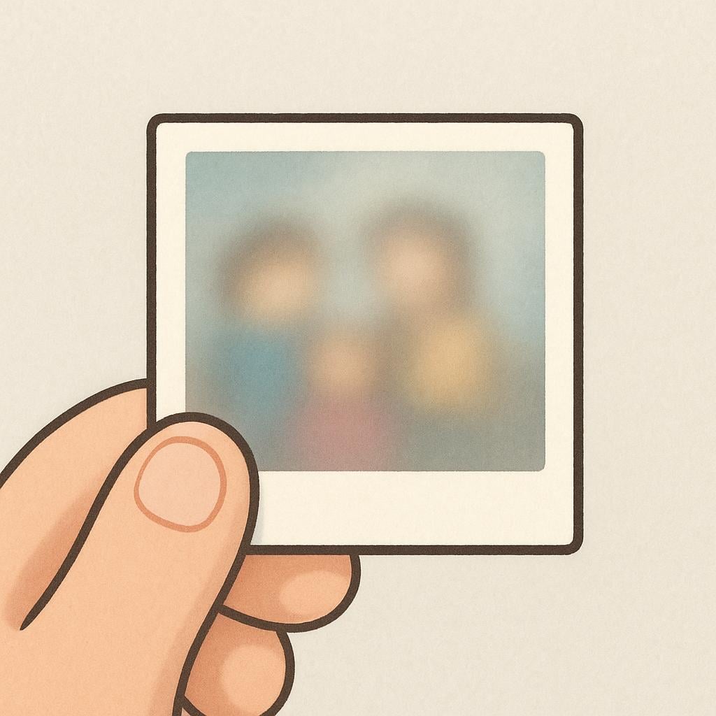 A small, square photograph held by two fingers, where the image on the photo is visibly blurred and indistinct.