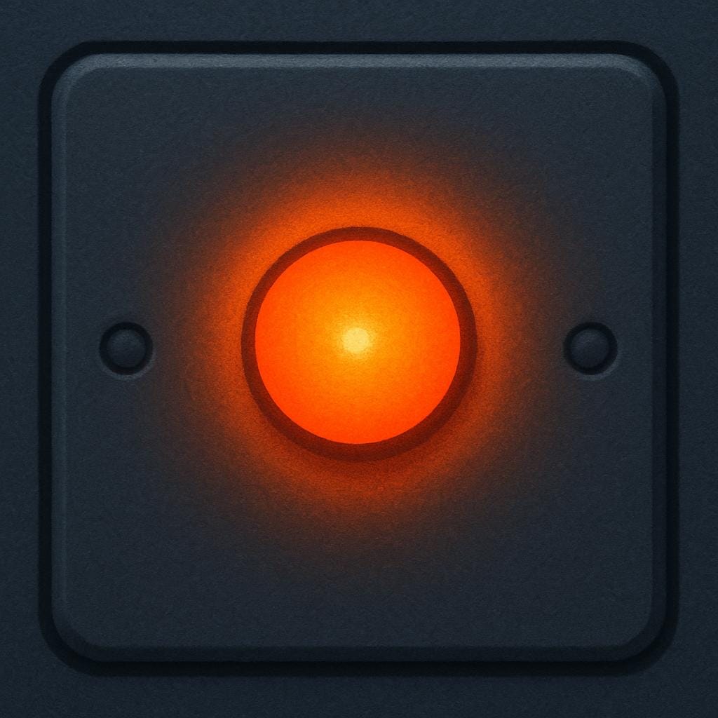 A close-up view of a simple grey appliance panel showing a single, small, bright orange indicator light glowing intensely.