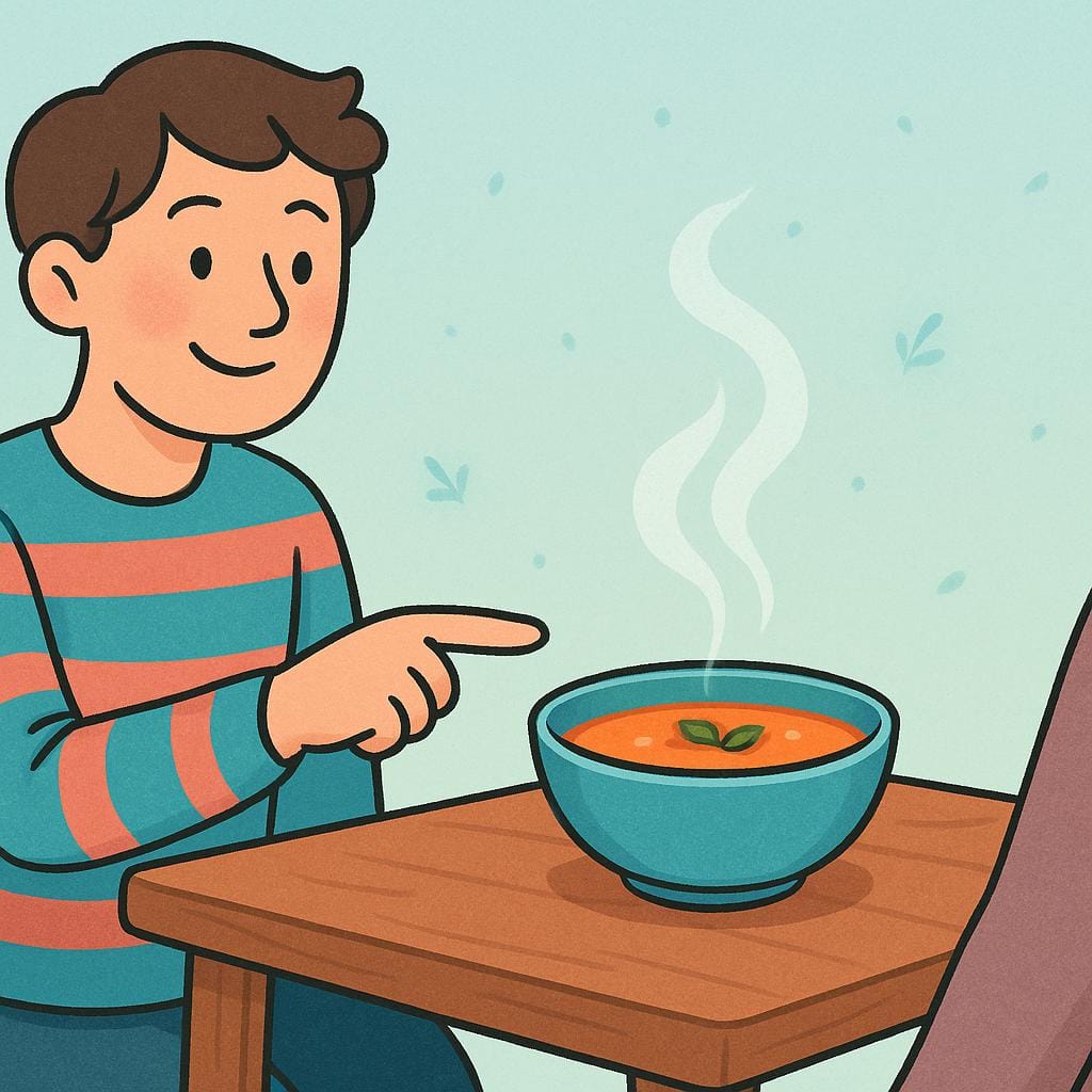 A friendly person smiling and pointing towards a delicious-looking bowl of steaming soup on a wooden table.