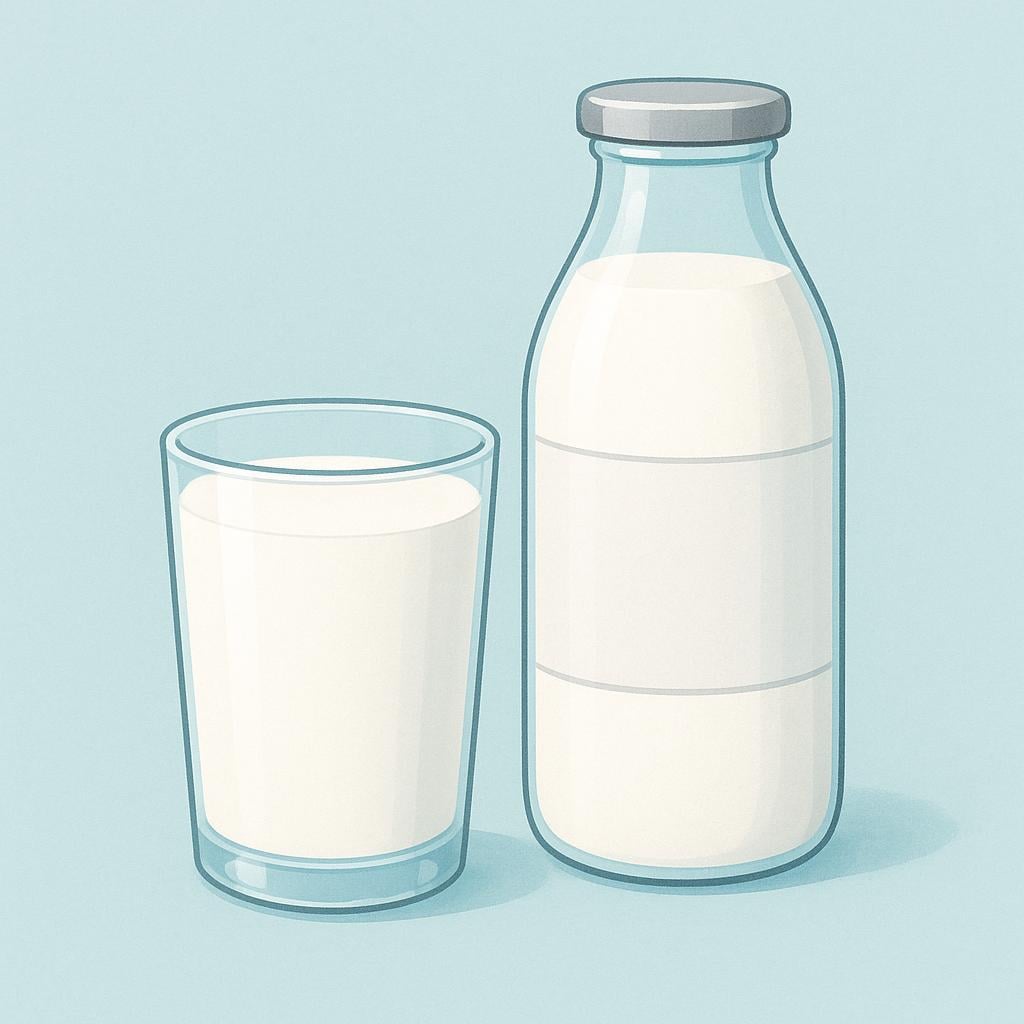 A tall, clear glass filled with white milk, sitting next to a traditional glass milk bottle with a silver foil cap.