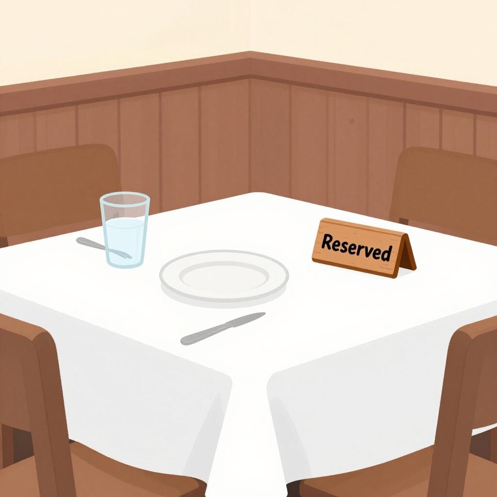 レストランのテーブルに置かれた、プレートとグラスの横にある「Reserved」と書かれた小さな木製サイン。