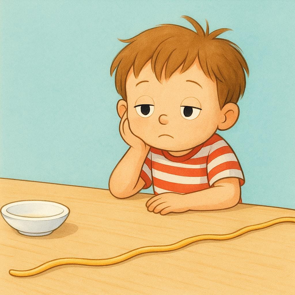 A child sits slumped at a wooden table, resting their head on their hand, looking extremely bored while staring at a single, long strand of spaghetti that stretches across the table.