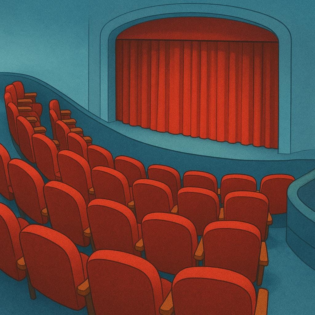 A view of red velvet theater seats arranged in a curved row overlooking a stage.